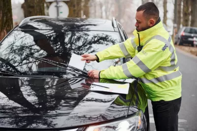 Polițist punând lista amenzilor în vehicul