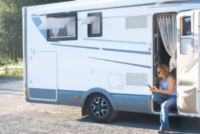 Travel woman sitting outside her camper van