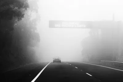 Autó az úton ködös időben és a közlekedési tábla "használja a vészvillogót"
