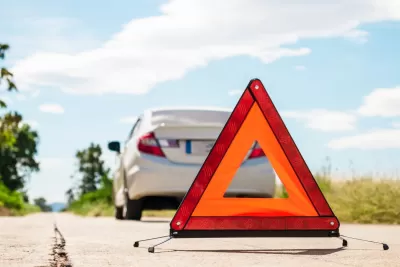 Znak za hitno zaustavljanje i pokvareni auto na cesti u Sloveniji